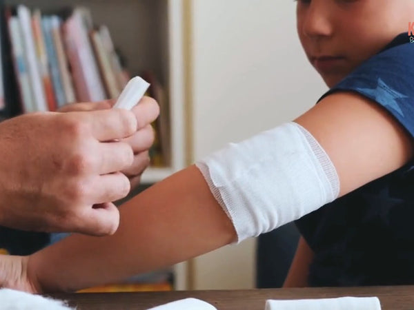 Ein Verband wird an einem Kinderarm angelegt