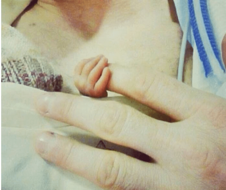 Foto: Winzige Babyhand umgreift den Finger eines Erwachsenen
